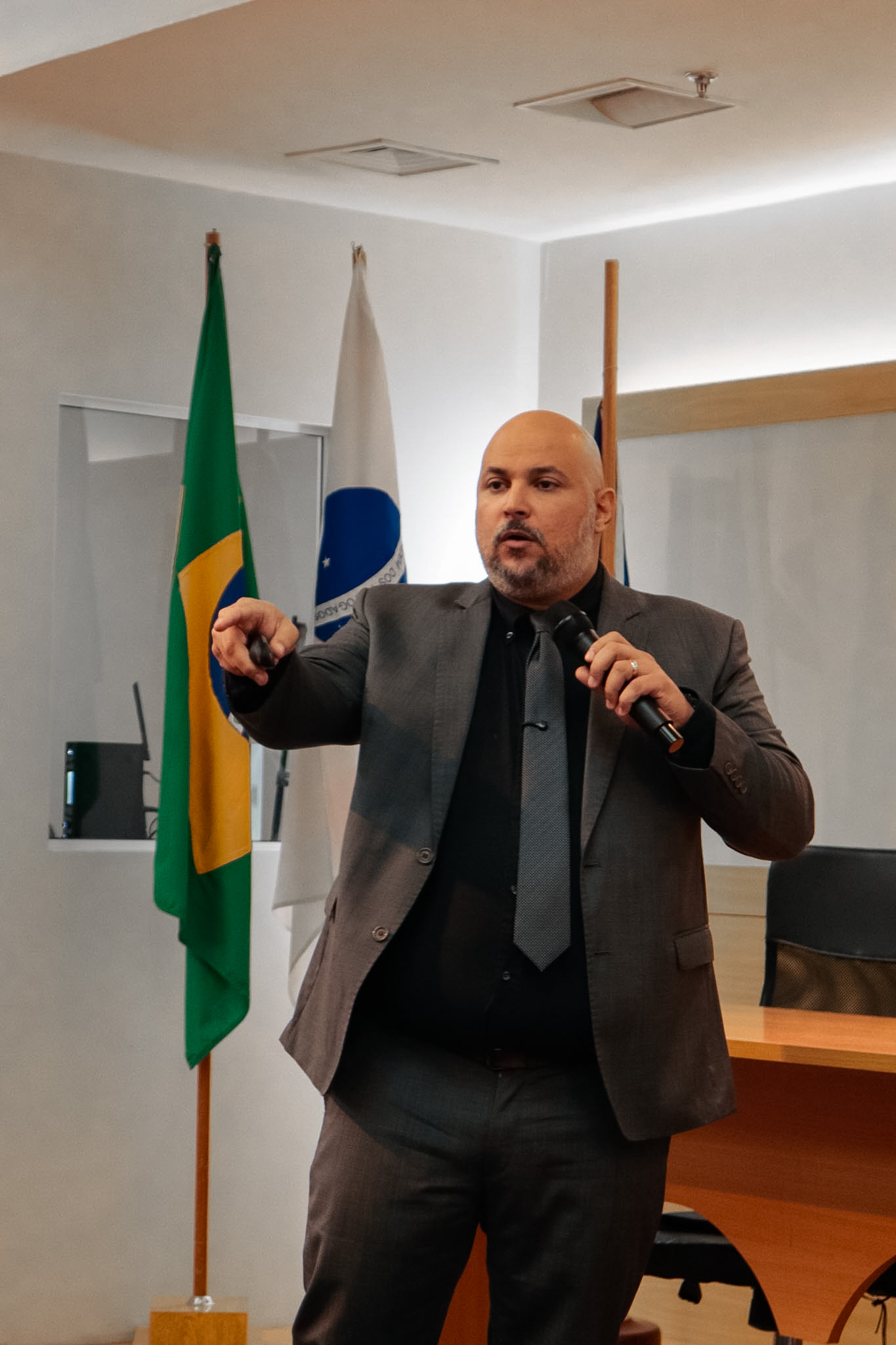 Leandro Muniz palestrando com microfone diante do público